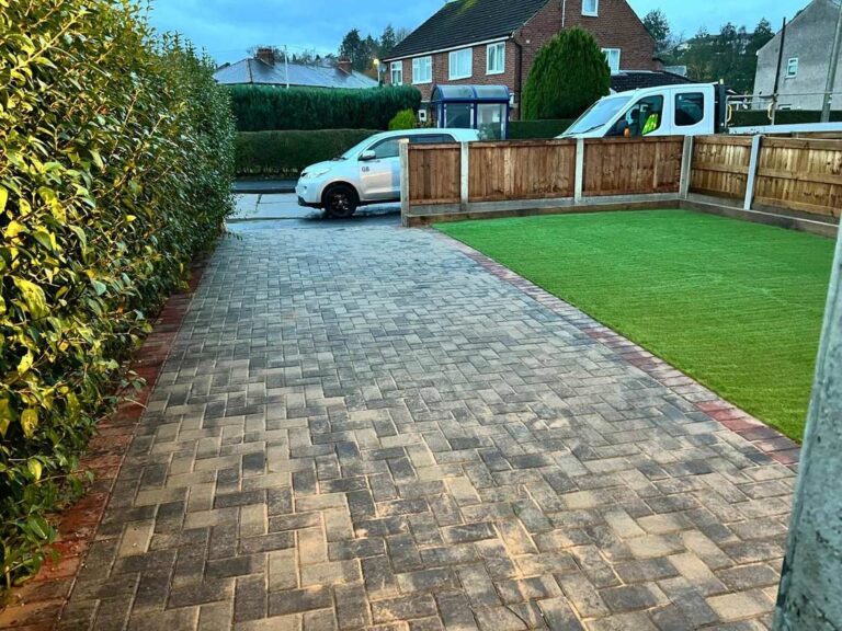 Block paved path beside artificial grass and a new fence