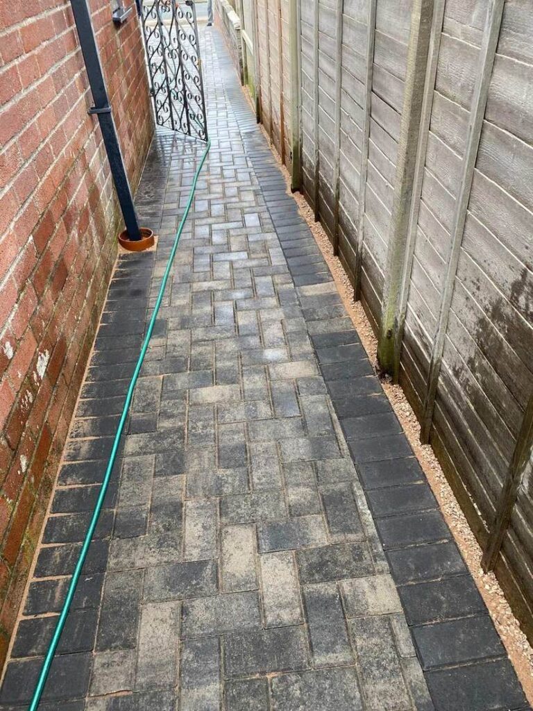 Block paved passage between a house and a fence
