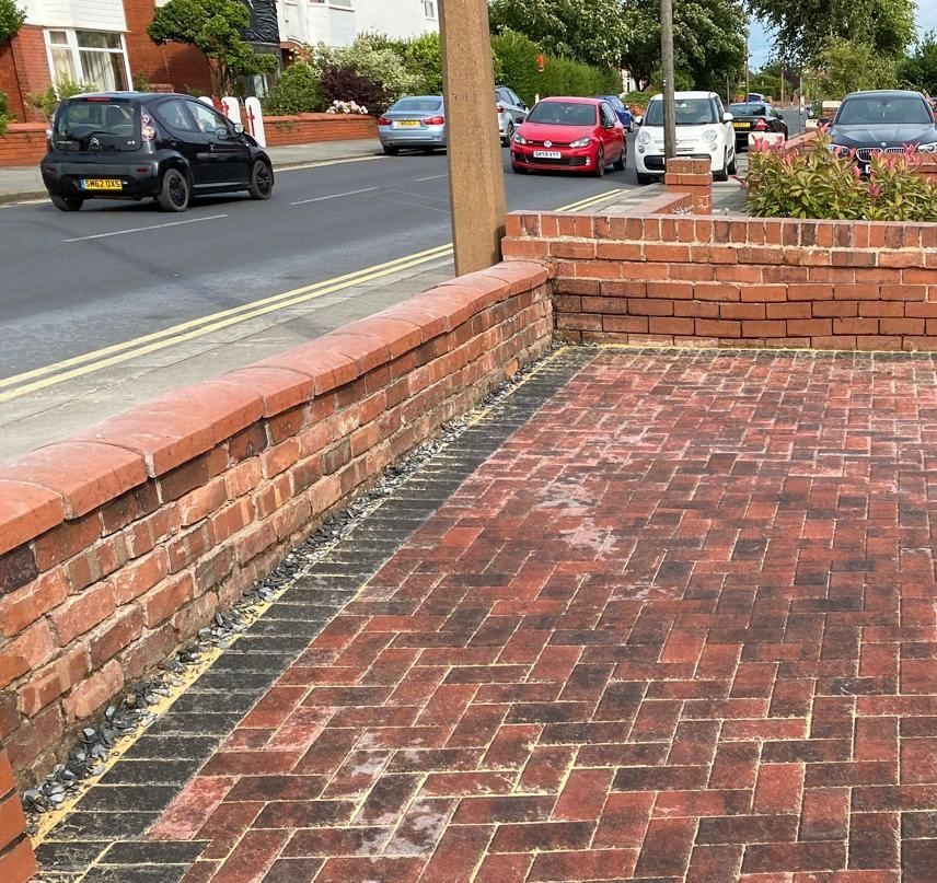 Brick garden wall beside red block paving