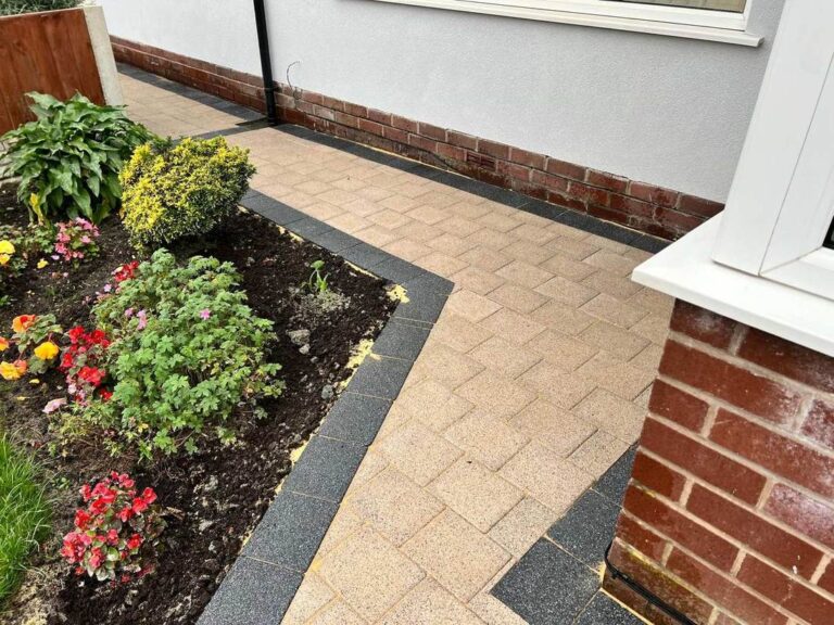 Buff block paved path beside a flower bed
