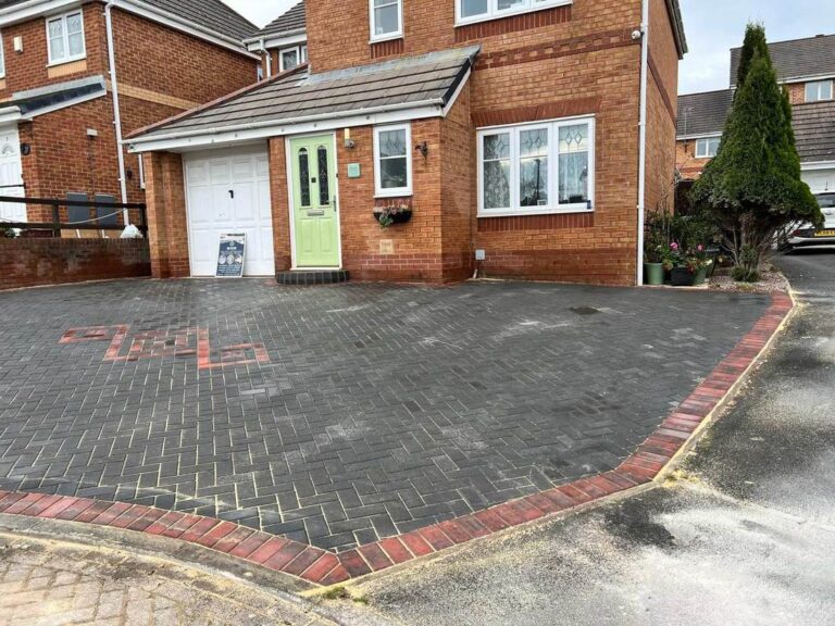 Charcoal block paved driveway with a red border