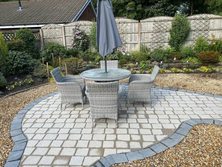 Circular cobble patio with garden furniture in gravel