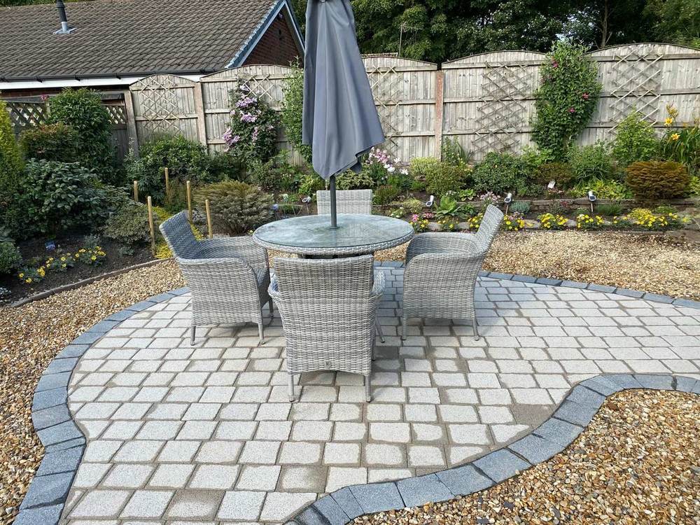 Circular cobble patio with garden furniture in gravel