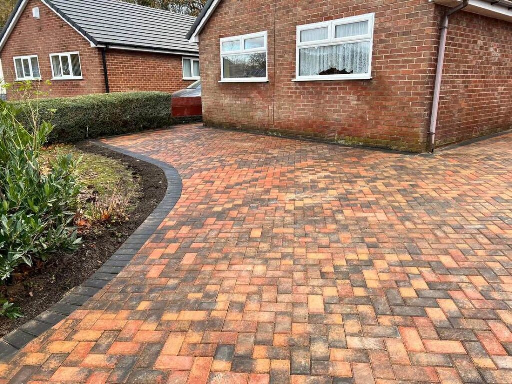 Curved herringbone block paved driveway with a charcoal edge