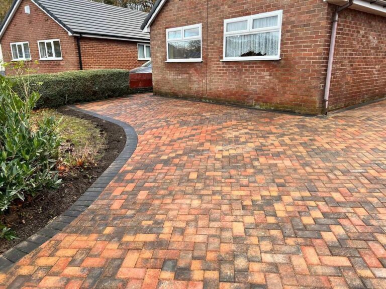 Curved herringbone block paved driveway with a charcoal edge