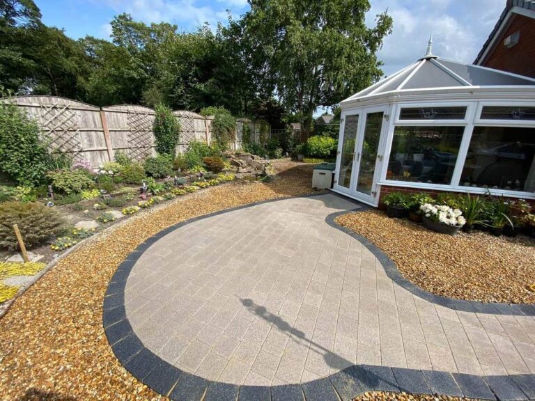 Curved block paved path to a conservatory through gravel