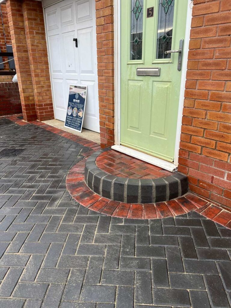 Curved brick step and herringbone paving at a front door