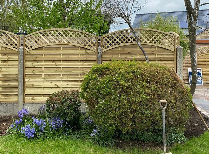 Decorative timber fence panels behind a garden border
