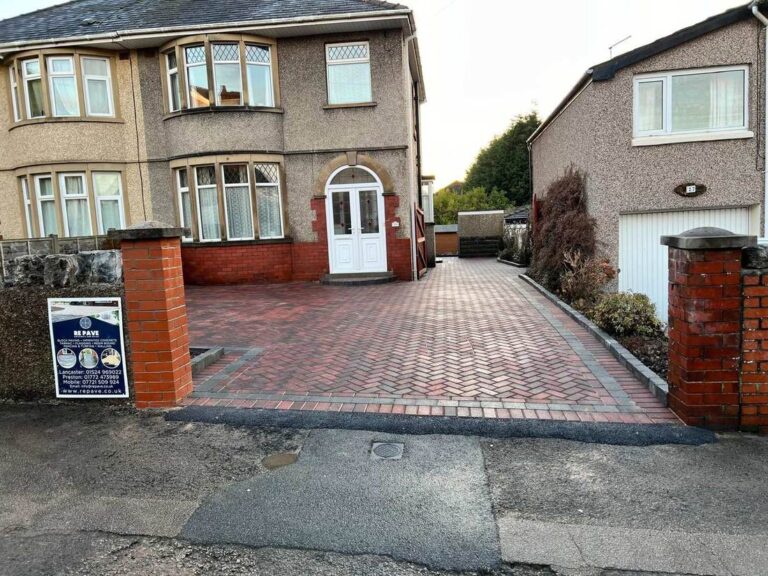 Herringbone block paved driveway between brick gate piers