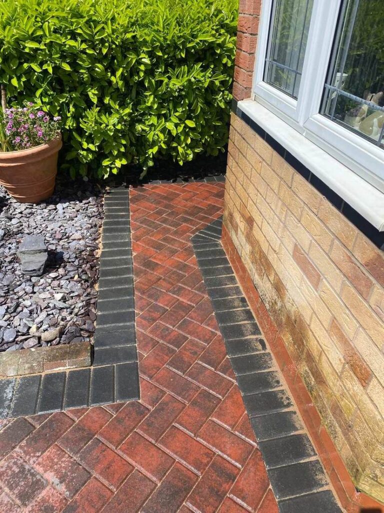 Narrow herringbone block path beside a gravel border