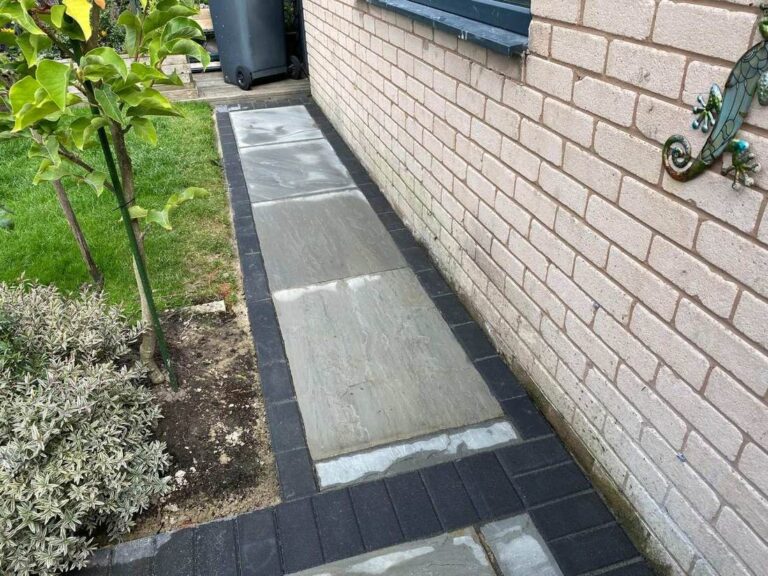 Grey porcelain path with a charcoal border beside a lawn