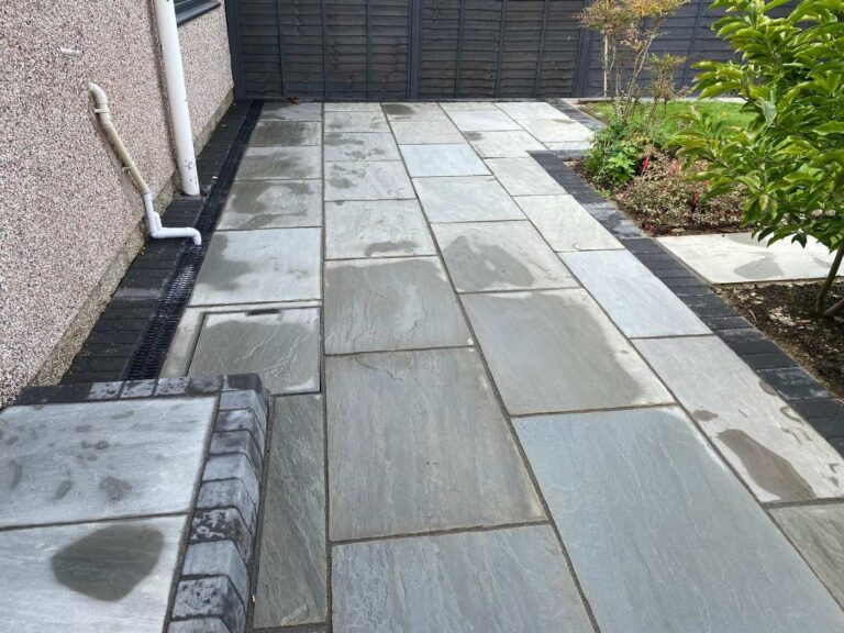 Grey porcelain patio with a charcoal block border