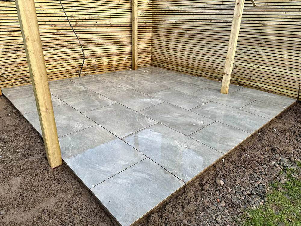 Grey porcelain patio inside a slatted fence