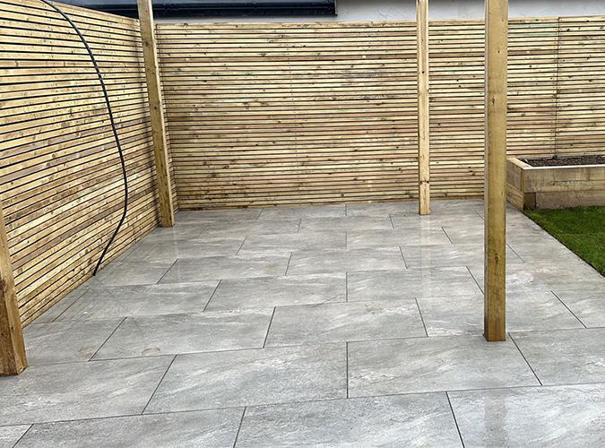 Grey porcelain patio inside a slatted fence