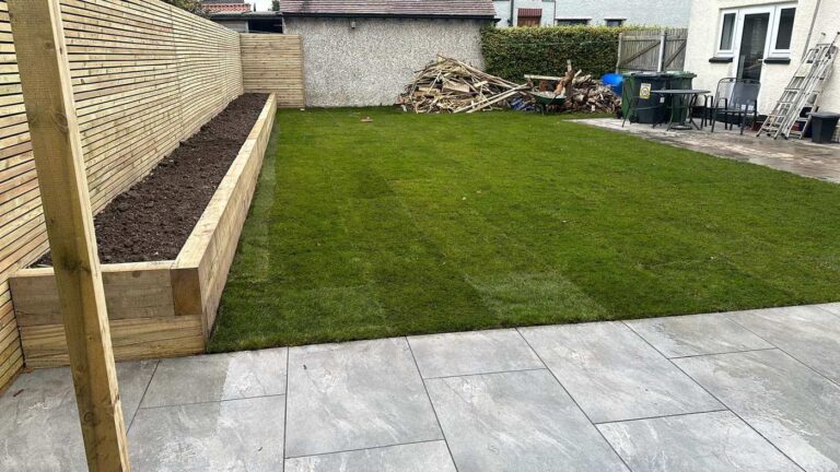 Porcelain patio with a sleeper planter and new turf