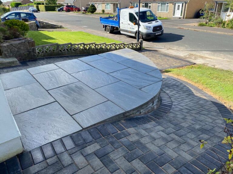 Raised grey porcelain patio with a curved edge