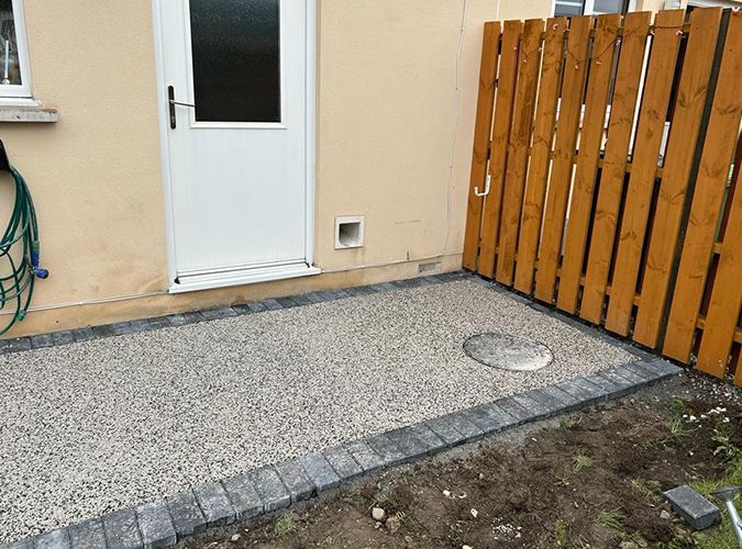 Light resin bound yard with a block edge and timber gate