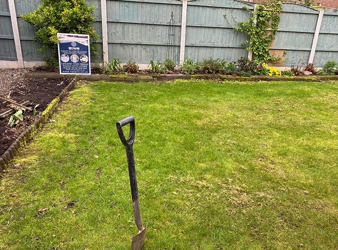 Newly laid rolled turf lawn beside a garden border
