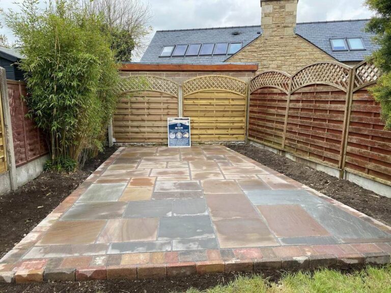 Indian sandstone patio in a fenced garden