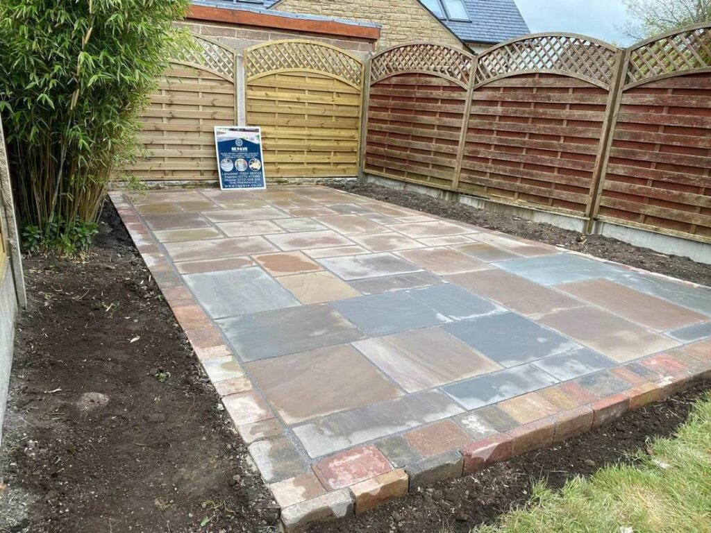 Indian sandstone patio in front of decorative fence panels