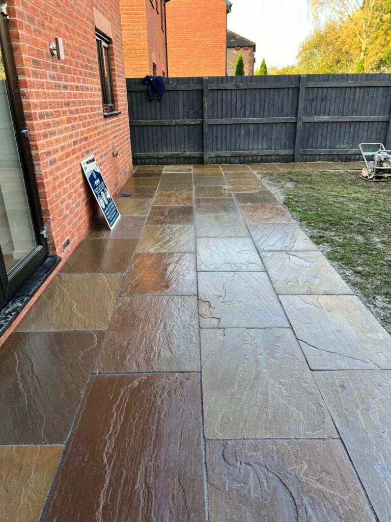 Indian sandstone patio along the side of a house