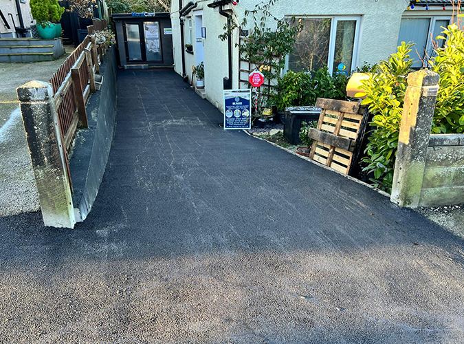 Tarmac driveway along the side of a house